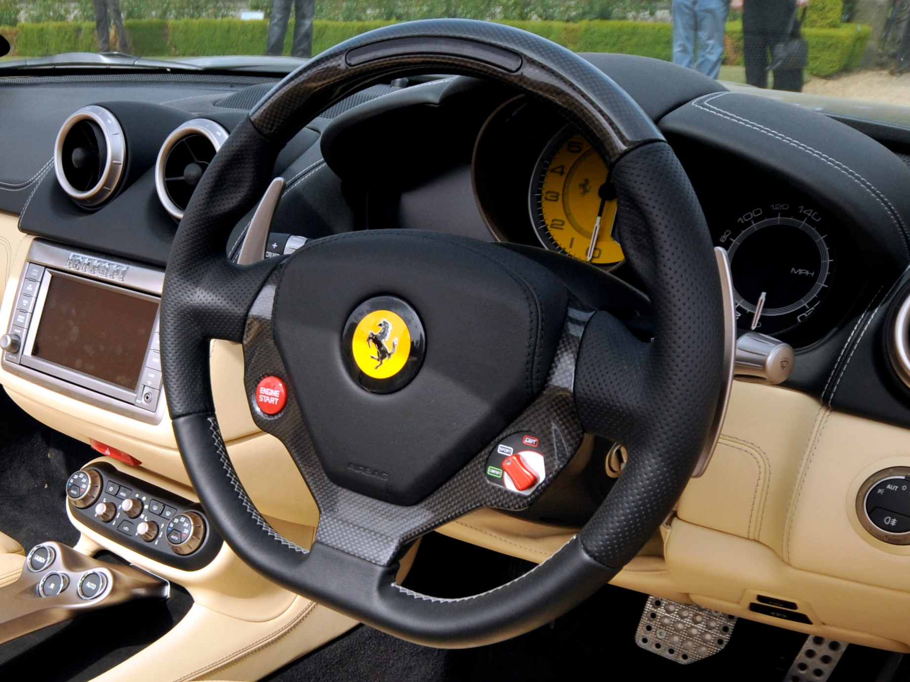 Ferrari cockpit: carbon steering wheel, engine start button and yellow rev counter.