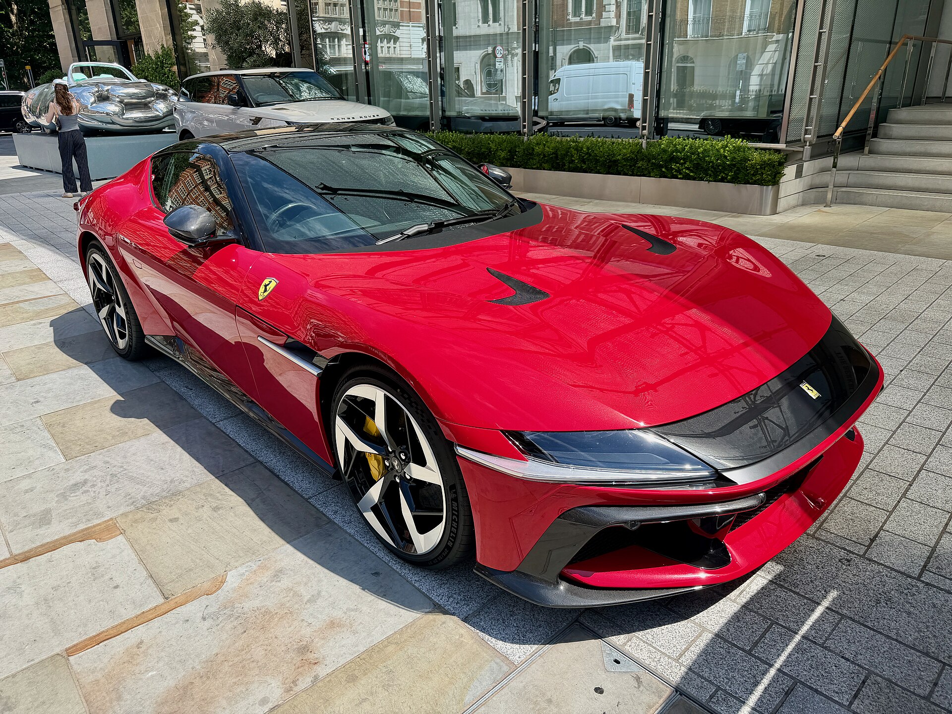 Ferrari 12Cilindri in red, three-quarter front, on a city forecourt.